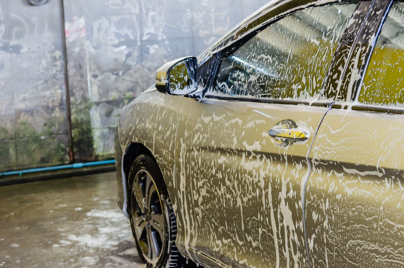 Before: a neglected sedan mid-wash, its dull paint still streaked with dirt and suds