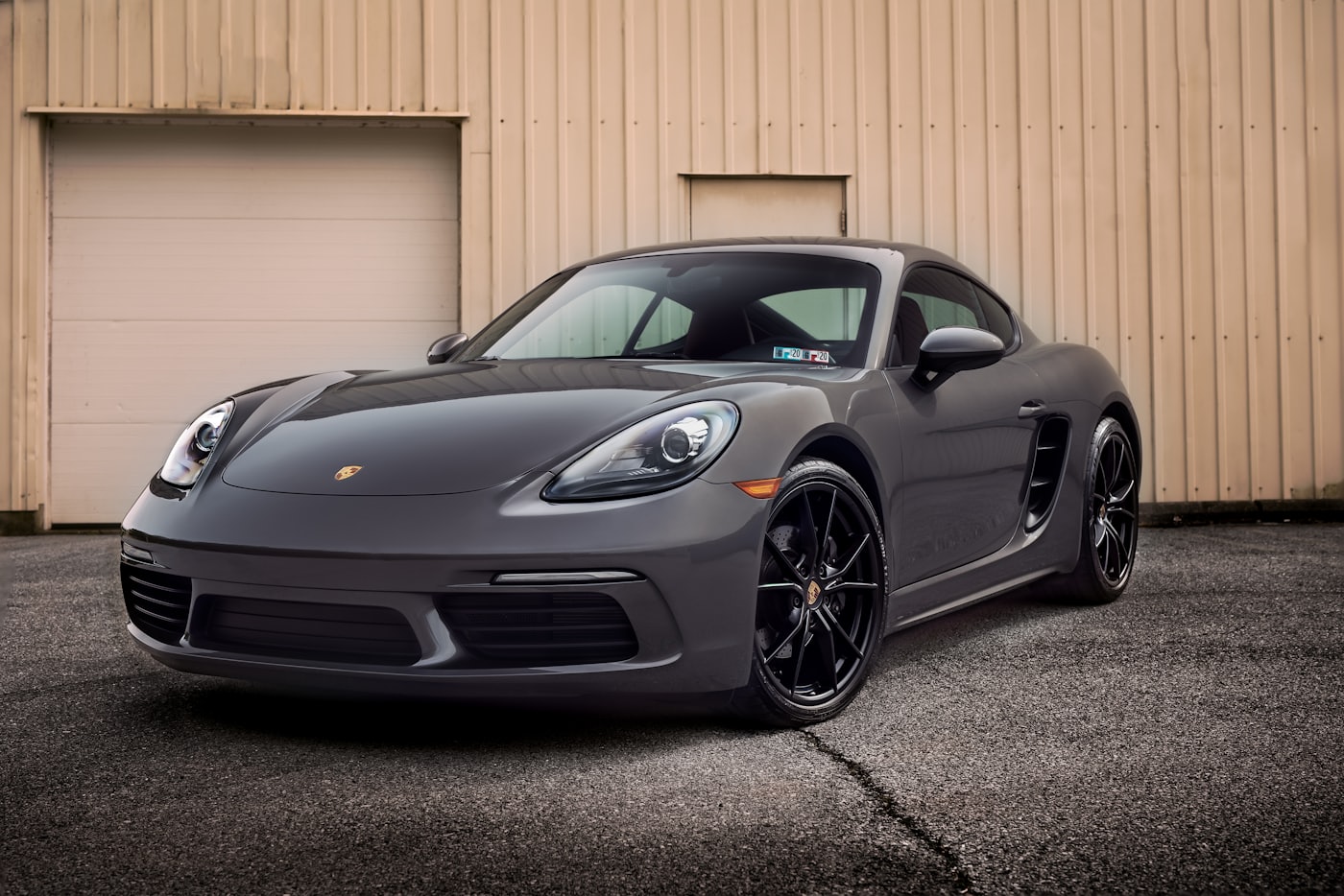 A graphite Porsche parked at the garage door of a residential Eastside home